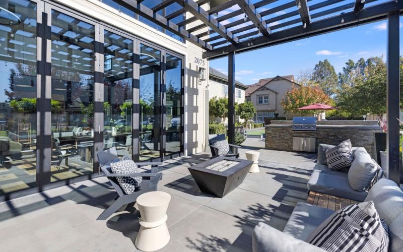a patio with a glass wall and a patio with a couch and chairs